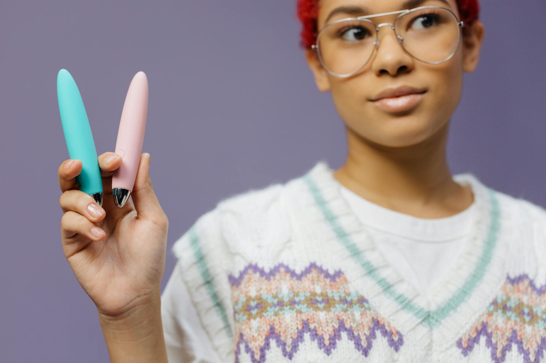 A person holding a colorful lemon clitoral vibrator while considering their pleasure on their own terms